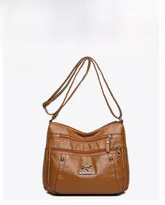 Front view detail of brown pebbled leather shoulder bag with zipper compartments