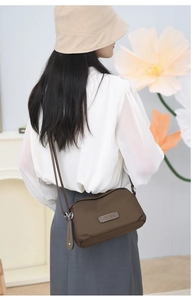 Close-up of brown waterproof Oxford shoulder bag featuring JIELSHI metal logo branding