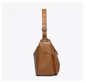 Side view of brown PU leather shoulder bag featuring side pockets and adjustable strap