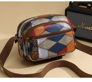 Detailed close-up of multi-pocket patchwork leather crossbody bag with zippers