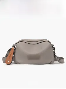 Close-up of waterproof grey oxford fabric and adjustable wide strap on crossbody bag
