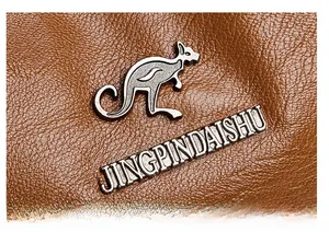 Close-up of a brown lychee-textured leather bag with a silver kangaroo metal logo