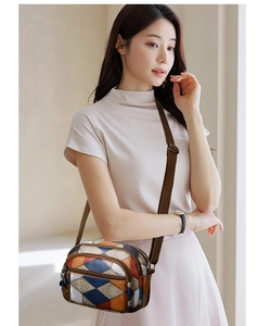 Detailed view of color-block crossbody bag featuring retro patchwork and multi-pocket design