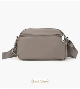 Detail view of the back zipper pocket and adjustable jacquard strap on the oxford bag