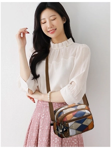 Detail of color-block crossbody bag with multi-pocket design and wide fabric shoulder strap