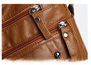 Detail of caramel brown PU leather bag showing litchi texture and silver metal zippers