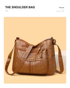 Detail of caramel brown washed soft leather crossbody bag with multiple zip pockets