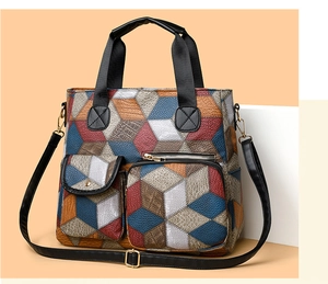 Detailed view of textured faux leather shoulder bag with dual front pockets and top handles