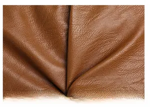 Close-up of premium brown PU leather material showing soft texture and lychee grain pattern