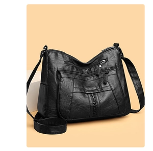 Detailed side view of black soft leather crossbody bag with multiple zipper pockets