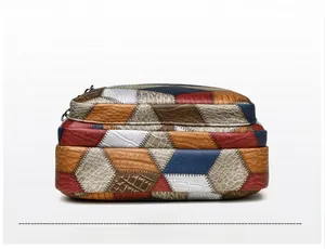 Detailed bottom view of a vintage multi-color patchwork shoulder bag with dual zippers