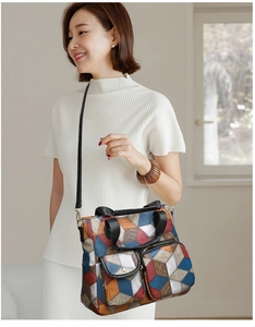 Detail of colorful geometric pattern handbag with dual front pockets and adjustable strap