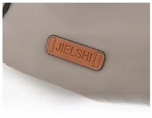 Detail view of water-resistant oxford fabric with a brown leather logo patch on the bag