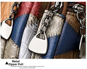 Detail of color-block leather bag with textured litchi grain and silver chain zipper pull