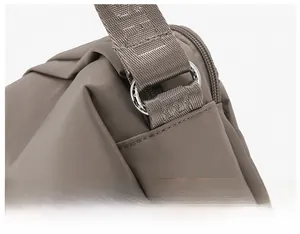 Macro view of silver metal D-ring buckle and durable Oxford fabric strap on crossbody bag