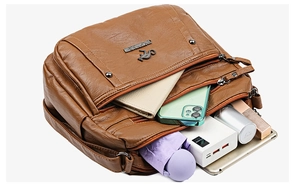 Brown PU leather bag with multiple zip compartments showing large interior storage space