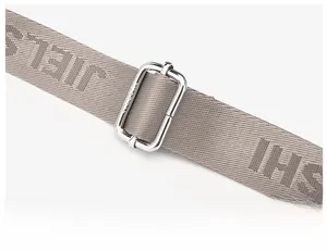 Close-up of adjustable gray nylon shoulder strap with silver metal buckle and woven logo