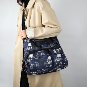 Navy tote bag with skull and floral prints worn with a beige trench coat