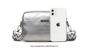 Silver metallic crossbody bag size comparison shown next to an iPhone 12 smartphone