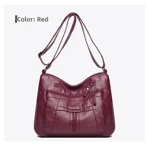 Detail of red soft leather crossbody bag with three zipper pockets and adjustable strap