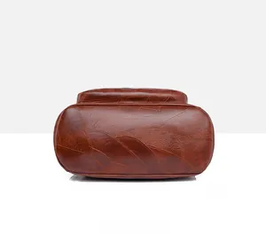 Detailed bottom view of brown leather patchwork bag with oval base and precise stitching
