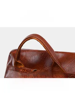 Close-up of brown textured leather handle with durable stitching on women shoulder bag