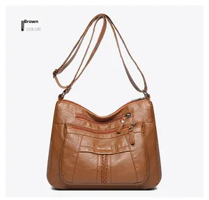Detailed view of brown washed leather crossbody bag with multiple zipper pockets