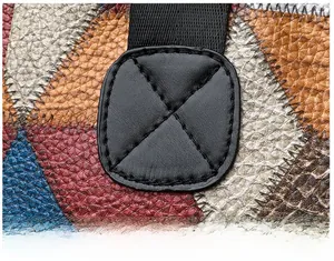 Macro detail of cross-stitched reinforcement on multi-color washed faux leather bag