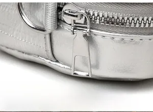 Macro shot of silver metal zipper and textured leather detail on the crossbody bag