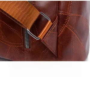 Detail of brown lychee leather texture with reinforced triangular stitching and metal ring