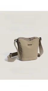 Detail view of khaki nylon bucket bag with adjustable strap and smooth fabric texture
