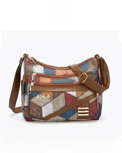 Vue frontale du sac bandoulière en similicuir avec patchwork géométrique et fermetures éclair