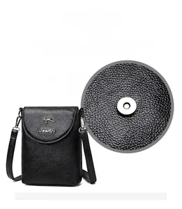 Detail of hardware magnetic closure on black lychee pattern leather shoulder phone bag