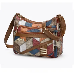 Détail d'un sac à bandoulière en patchwork de cuir PU avec zips et rivets dorés