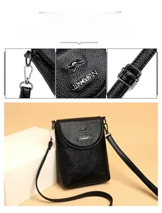 Detail of black litchi grain leather crossbody bag with silver kangaroo logo and strap