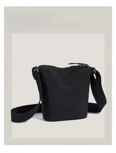 Detail shot of the multi-layered zipper design and nylon texture on this black bucket bag