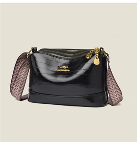 Close-up of black oily leather handbag featuring gold kangaroo logo and ethnic wide strap