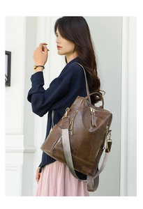 Detail of dark brown faux leather backpack with leaf vein stitching and side pockets