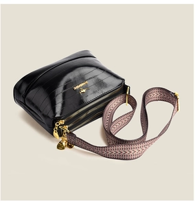 Close-up of triple zipper compartments and textured faux leather on women's shoulder bag