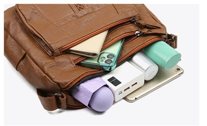 Macro view of multi-compartment brown leather bag showing large storage capacity