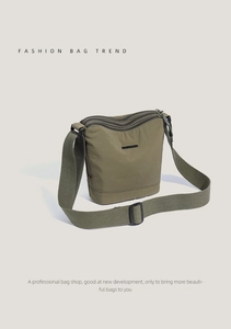 Detail view of olive green nylon crossbody bag with multi-zipper and adjustable wide strap