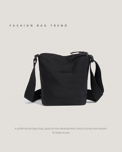 Detail of black nylon bucket bag featuring adjustable wide strap and BAOJANGREN branding