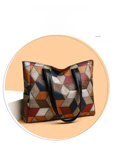 Dettaglio della pelle patchwork geometrica e delle cuciture su una grande borsa tote