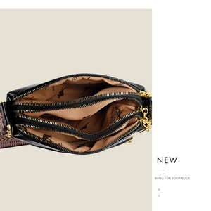 Internal view of crossbody bag showing three zippered compartments and woven strap