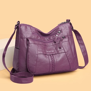 Detail view of purple washed leather crossbody bag with multiple zipper pockets