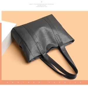 Vista dettagliata della borsa tote in pelle grigio scuro con trama a litchi e spalline robuste