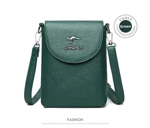 Detail of dark green pebble leather crossbody bag with kangaroo logo and adjustable strap