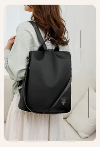 Rear view of black waterproof oxford backpack with anti-theft zipper on model in home setting