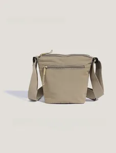 Detail view of khaki nylon bucket bag showing durable fabric and front zipper pocket