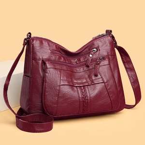 Close-up of deep red washed leather crossbody bag showing three-layer zipper details